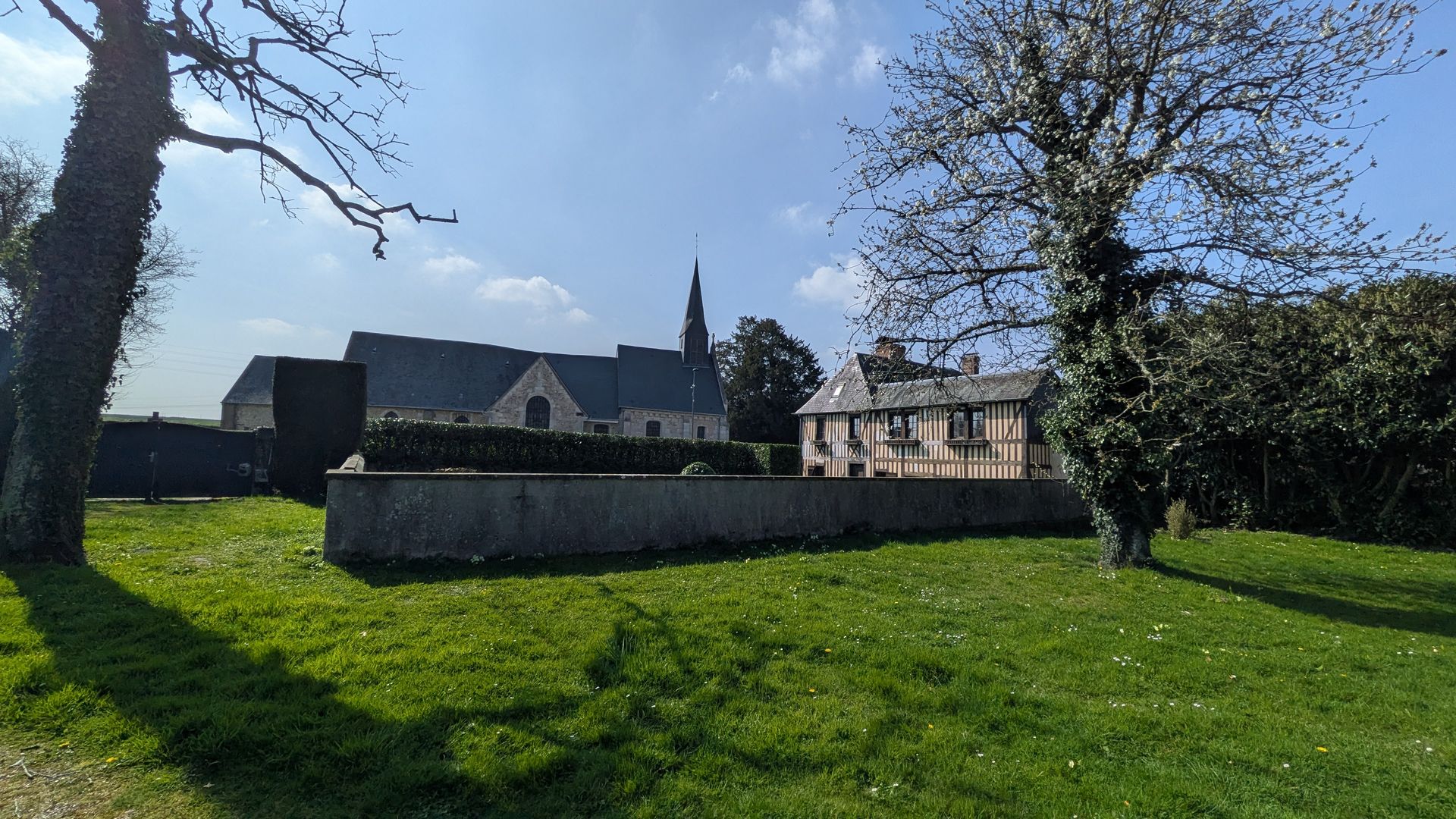 Le Presbytère — vue depuis le jardin avec l'église en arrière-plan